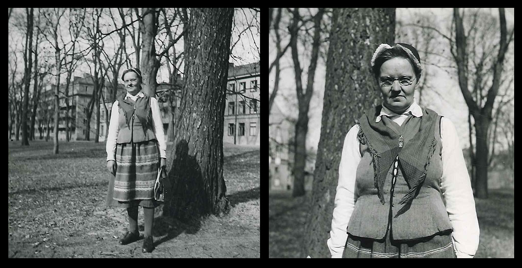 Kvinna i folkdräkt fotograferad i parkmiljö.
